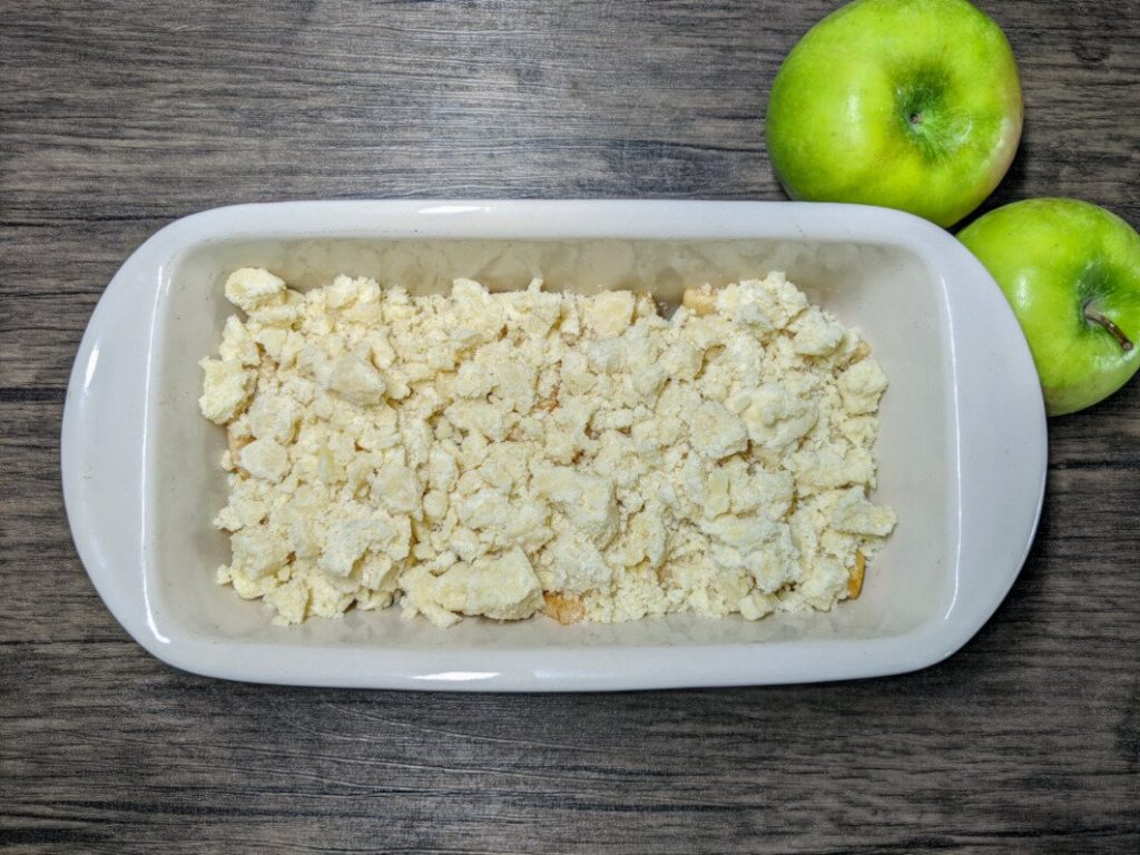 Jabłka posypane kruszonką w formie do pieczenia.