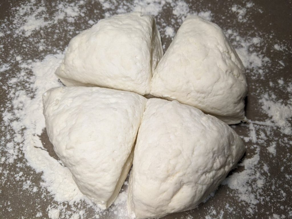 Ciasto na pizzę podzielone na 4 części